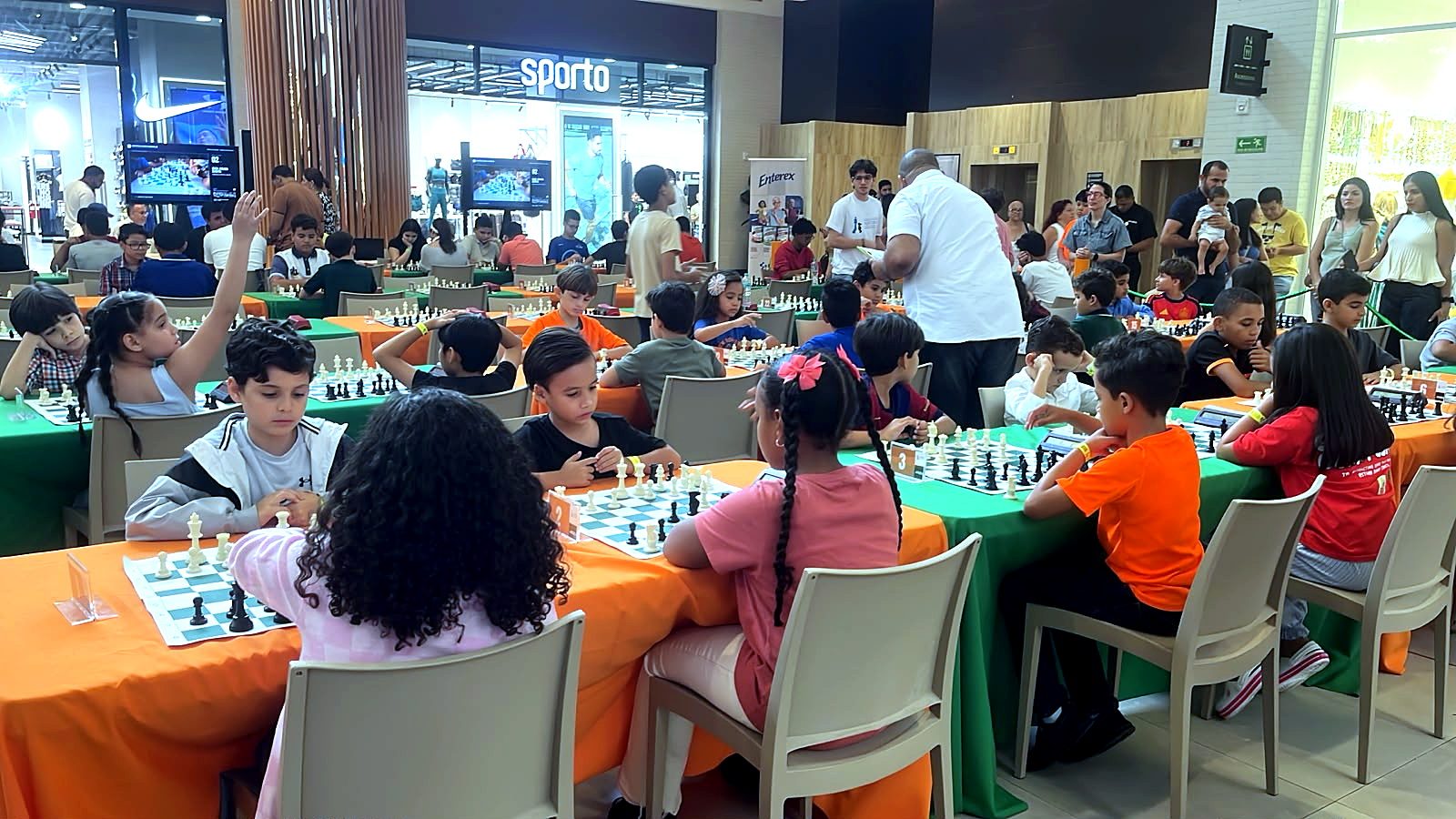 Sala llena de niños jugando ajedrez durante el torneo infantil en Ágora Santiago Center