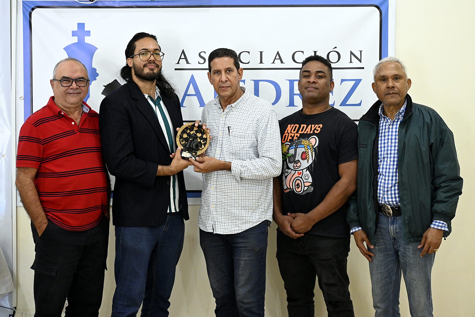 El campeón recibe el trofeo junto a directivos